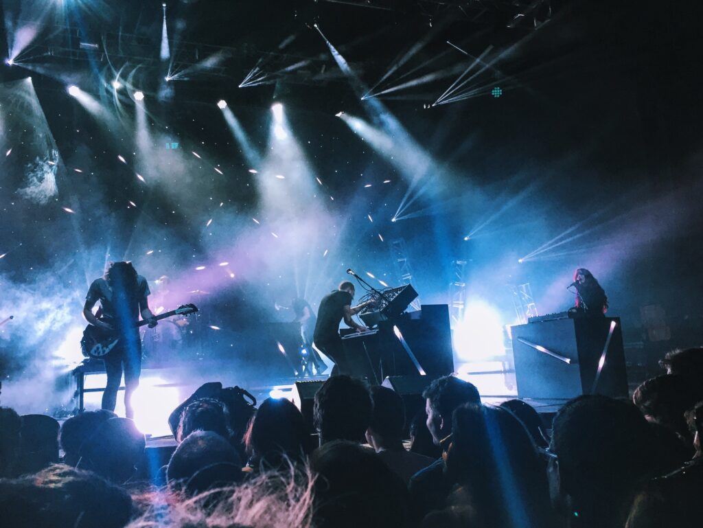 A crowd of people in front of lights at night.