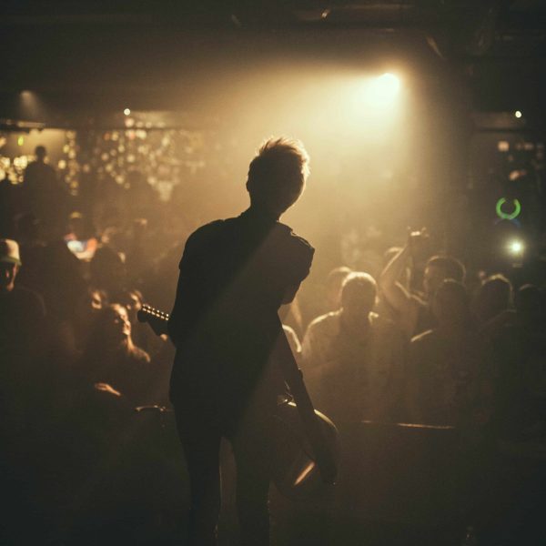 A person standing in front of a crowd at night.